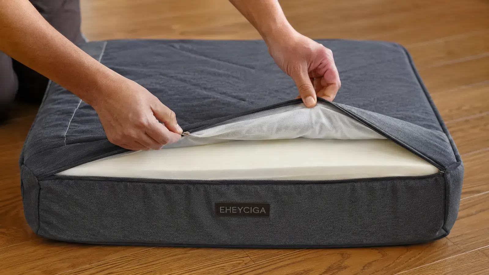 Hands unzipping the cover of the EHEYCIGA orthopedic dog bed to show the foam insert inside